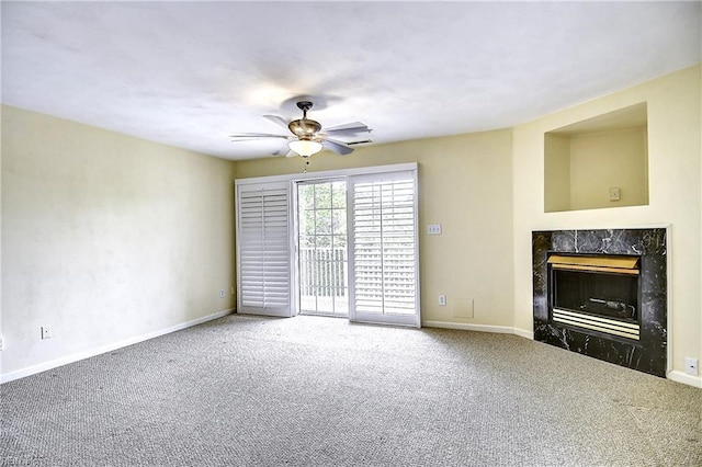 unfurnished living room featuring ceiling fan, carpet flooring, a high end fireplace, and baseboards