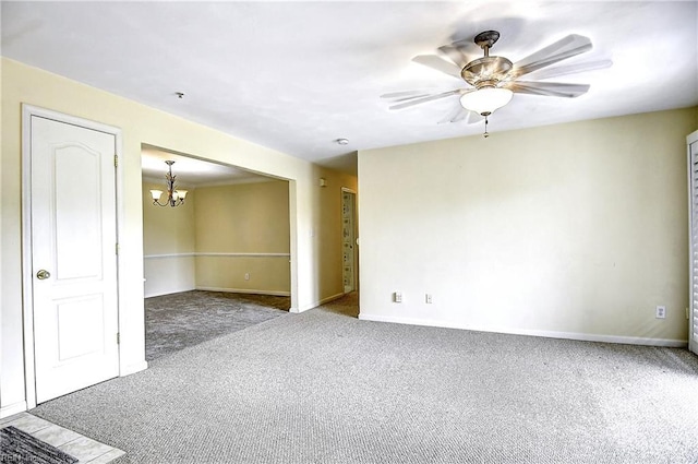 unfurnished room featuring baseboards, ceiling fan with notable chandelier, and carpet floors