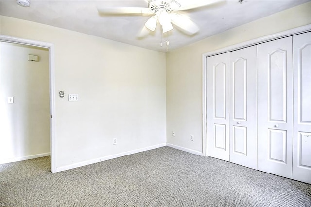 unfurnished bedroom with ceiling fan, baseboards, carpet flooring, and a closet