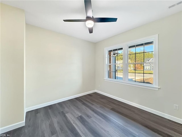 unfurnished room featuring dark wood-style flooring, visible vents, a ceiling fan, and baseboards