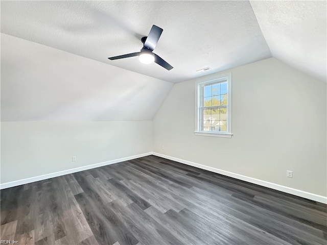 bonus room featuring lofted ceiling, dark wood-type flooring, visible vents, and baseboards