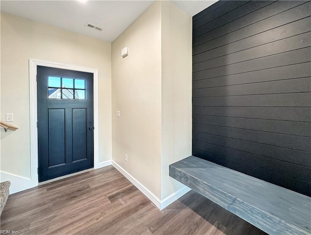 foyer with visible vents, wood finished floors, and baseboards