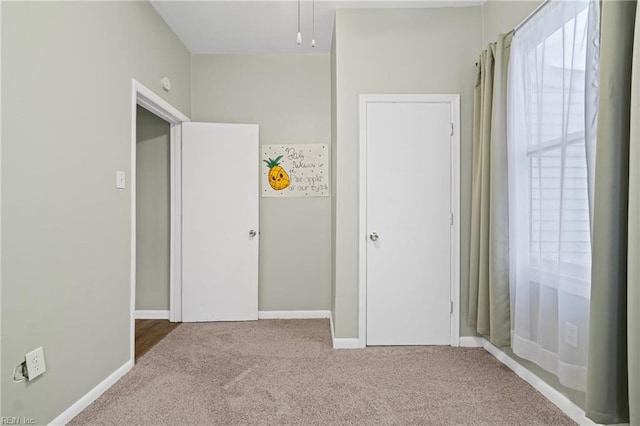 unfurnished bedroom featuring baseboards and carpet flooring