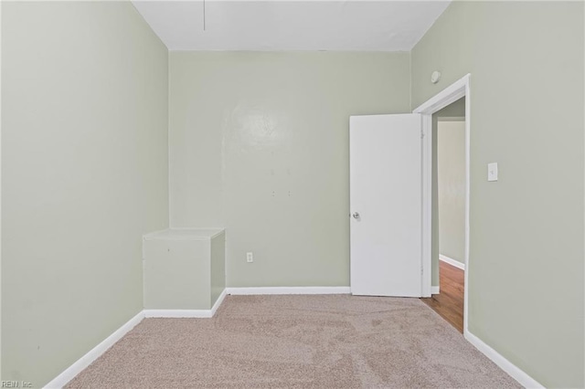 carpeted spare room featuring baseboards