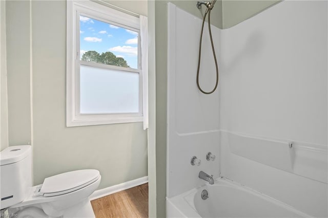 full bathroom with wood finished floors, shower / washtub combination, toilet, and baseboards