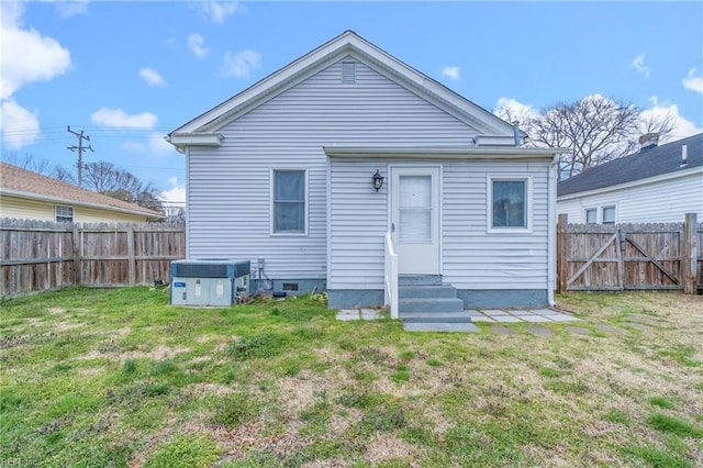 back of property with a lawn, central air condition unit, entry steps, and a fenced backyard