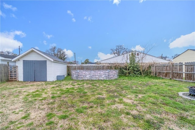 view of yard featuring a fenced backyard, a shed, and an outdoor structure
