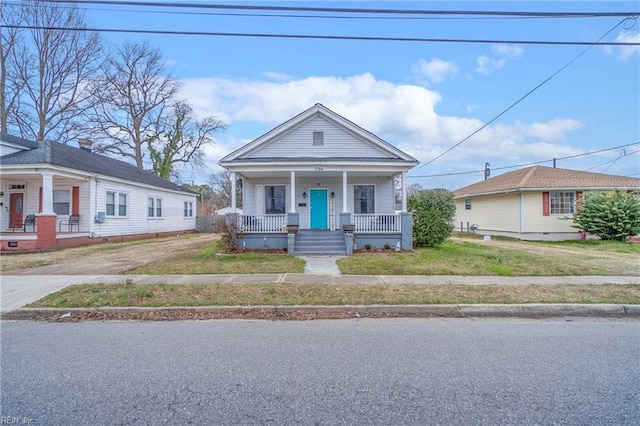 view of front of home featuring driveway, a porch, and a front lawn