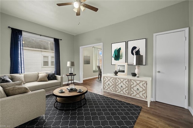 living room featuring baseboards, wood finished floors, and ceiling fan