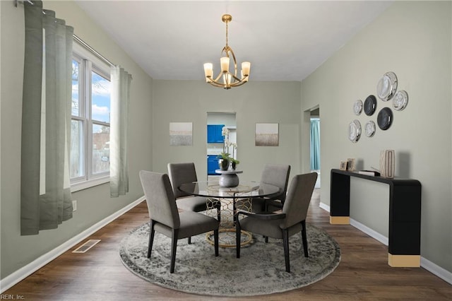 dining area featuring an inviting chandelier, wood finished floors, and plenty of natural light