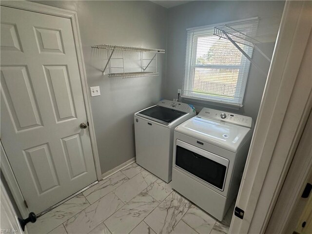 clothes washing area with marble finish floor, baseboards, laundry area, and washer and clothes dryer