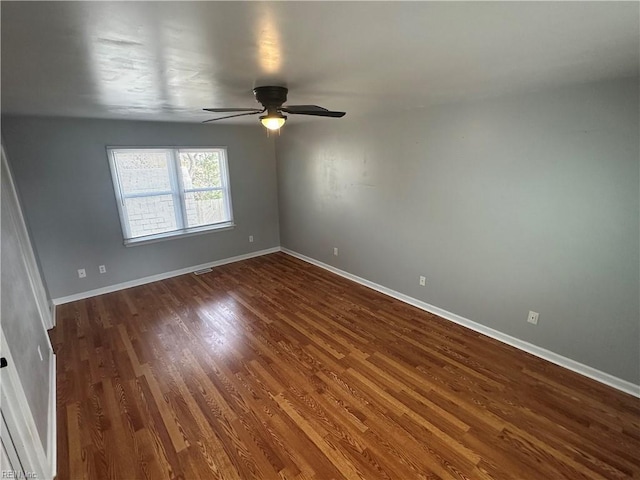 unfurnished room featuring baseboards, a ceiling fan, and dark wood-style flooring
