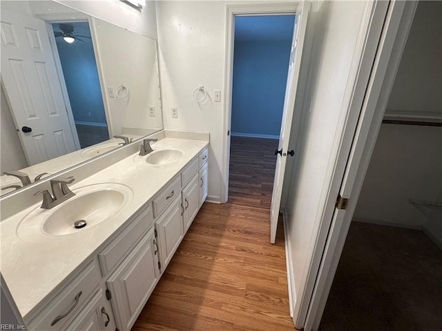 full bath featuring wood finished floors, double vanity, and a sink