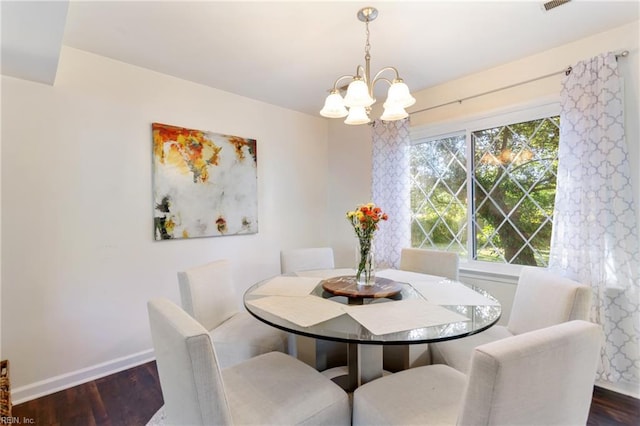 dining space with baseboards, dark wood-type flooring, and a chandelier