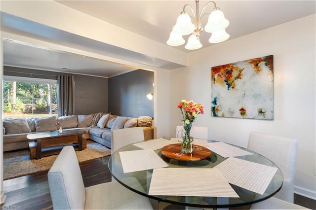 dining room featuring an inviting chandelier and dark wood-style flooring