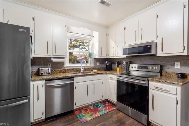 kitchen featuring visible vents, appliances with stainless steel finishes, tasteful backsplash, a sink, and white cabinets