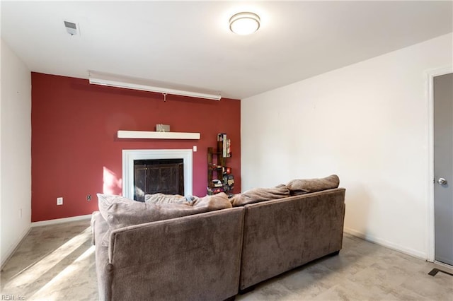 living room featuring a glass covered fireplace and baseboards