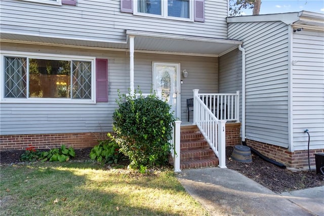 doorway to property featuring a lawn