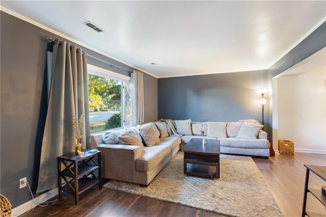 living area featuring visible vents, ornamental molding, baseboards, and wood finished floors