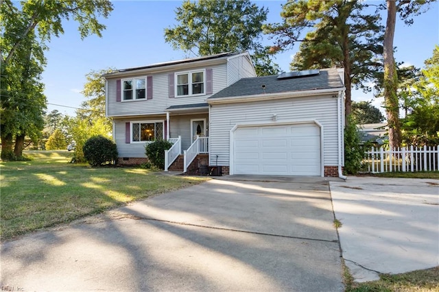 view of front facade with a garage, fence, a front yard, roof mounted solar panels, and concrete driveway