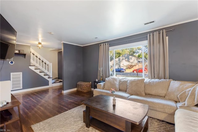 living area with stairs, baseboards, visible vents, and wood finished floors