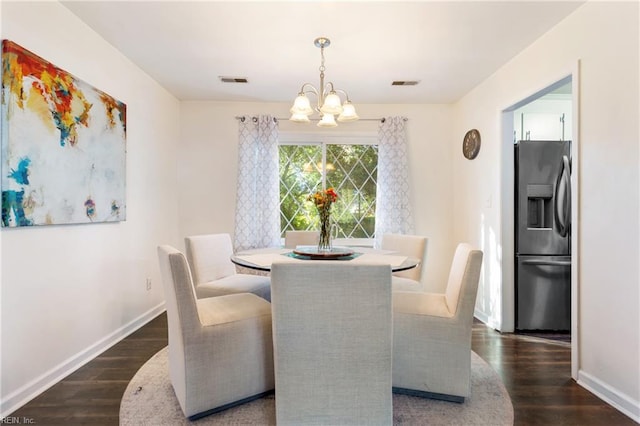 dining room with baseboards, visible vents, dark wood-style floors, and a notable chandelier