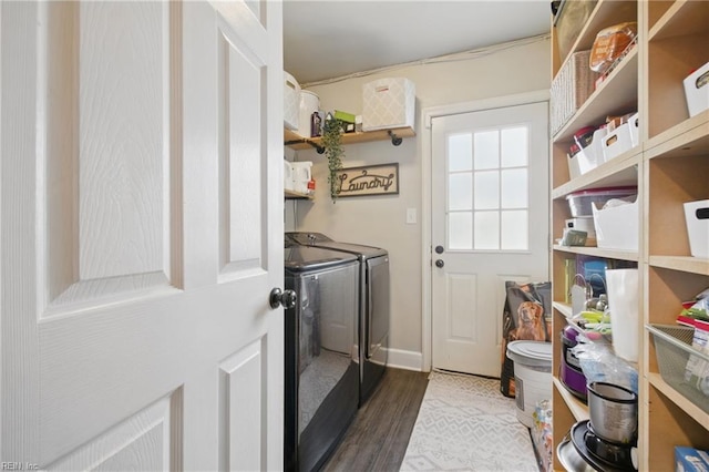 laundry room featuring baseboards, wood finished floors, laundry area, and washer and clothes dryer