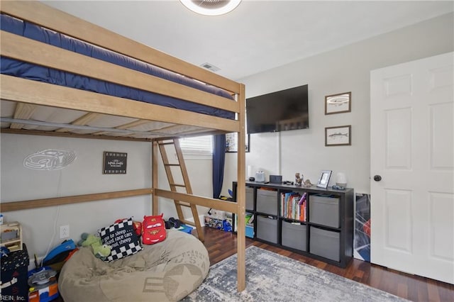 bedroom featuring visible vents and wood finished floors