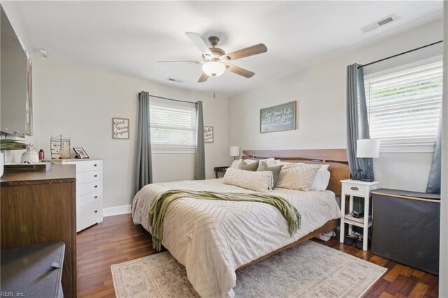 bedroom featuring visible vents, a ceiling fan, and dark wood-style floors