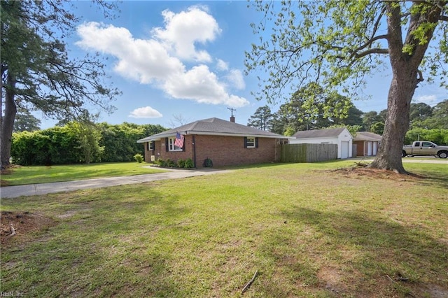 view of side of property with fence, a chimney, a lawn, and brick siding