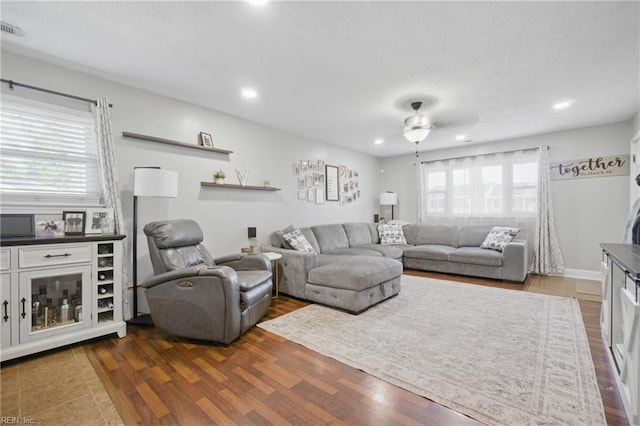 living room with dark wood-style floors, recessed lighting, visible vents, and a ceiling fan