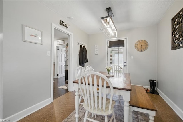 dining area featuring a textured ceiling and baseboards