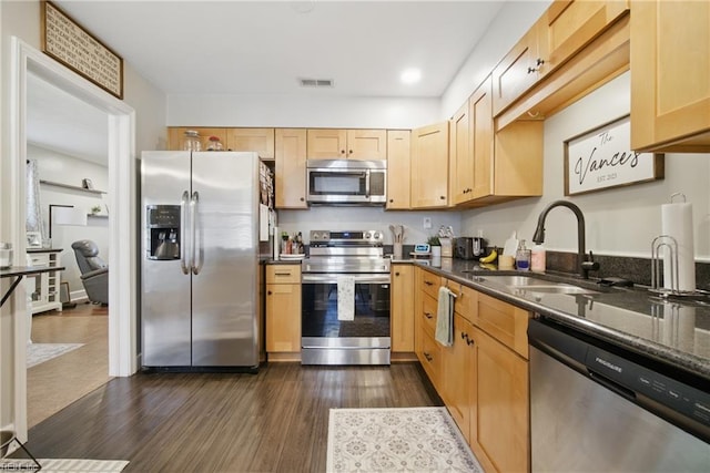 kitchen featuring a sink, light brown cabinets, stainless steel appliances, and dark wood finished floors