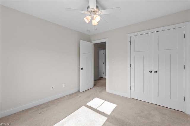 unfurnished bedroom with baseboards, light carpet, ceiling fan, and a closet