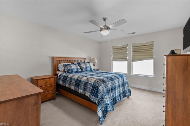 bedroom featuring baseboards, light carpet, a ceiling fan, and visible vents