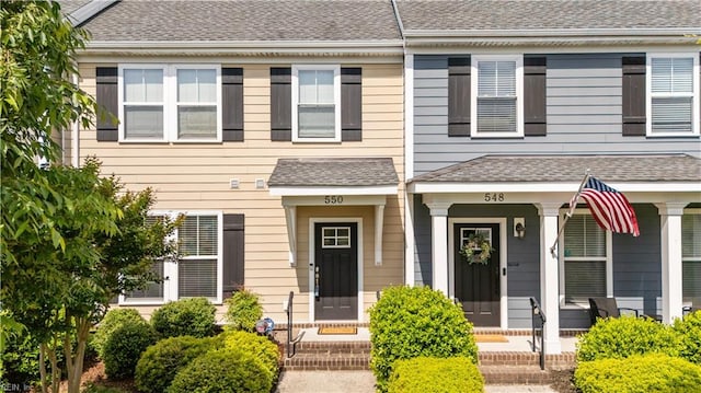 multi unit property with covered porch and a shingled roof