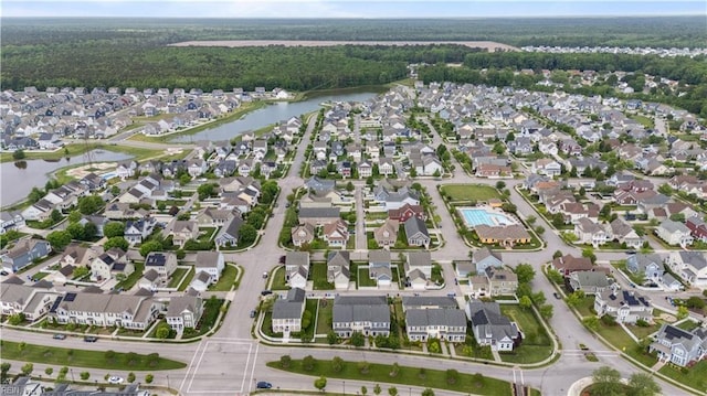 birds eye view of property with a wooded view, a water view, and a residential view