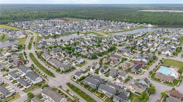 bird's eye view with a water view, a view of trees, and a residential view