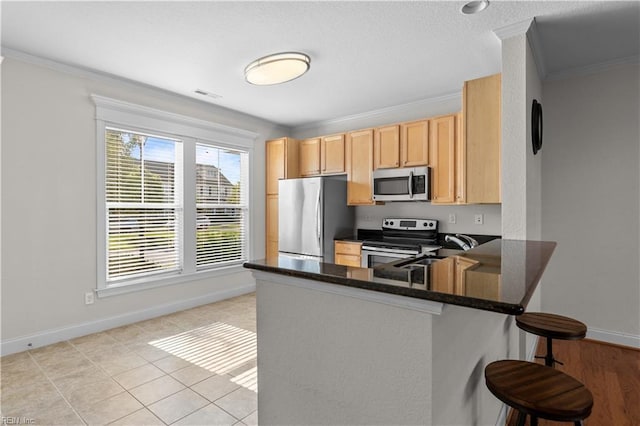 kitchen with dark countertops, baseboards, stainless steel appliances, and visible vents