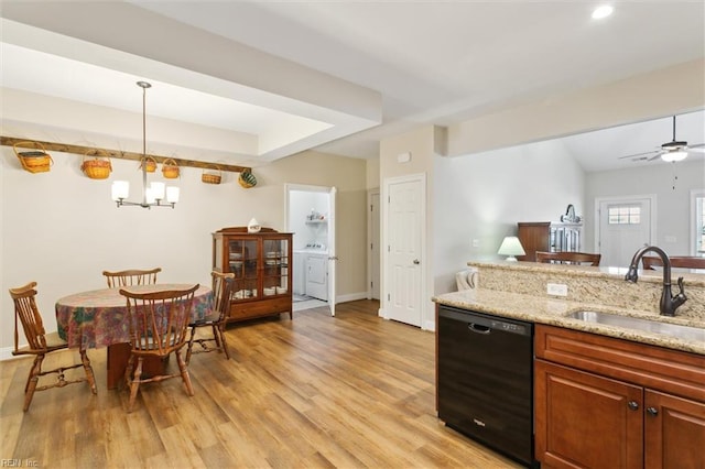 kitchen with a sink, light wood-style floors, black dishwasher, and independent washer and dryer