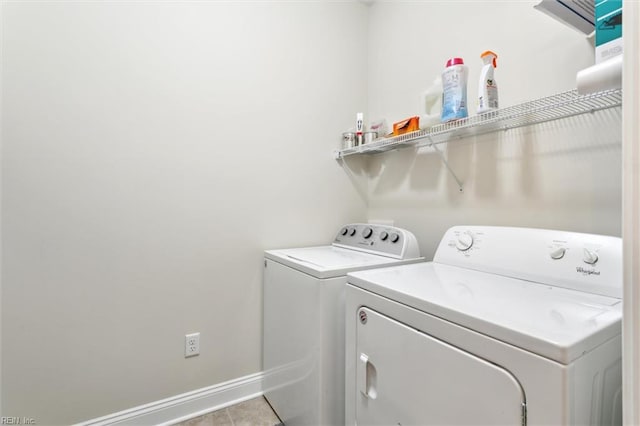washroom featuring washer and dryer, laundry area, baseboards, and tile patterned flooring