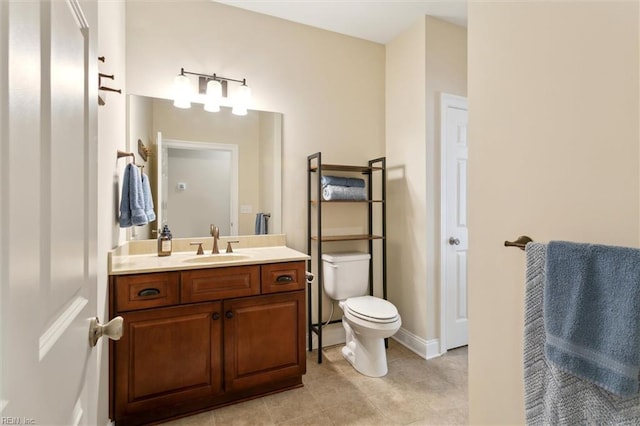 bathroom with vanity, tile patterned floors, baseboards, and toilet