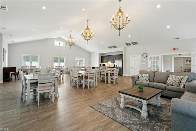 living area with visible vents, wood finished floors, and a notable chandelier