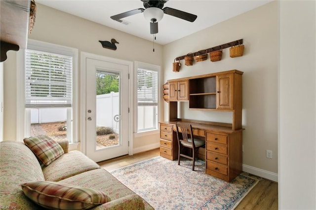home office featuring baseboards, a ceiling fan, and light wood-style flooring