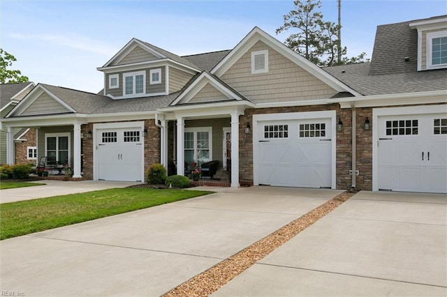 view of front of home with roof with shingles, driveway, and stone siding