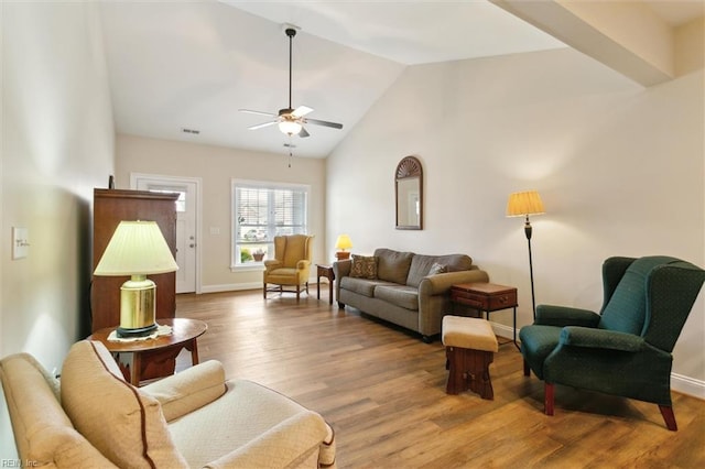 living room featuring visible vents, a ceiling fan, wood finished floors, and vaulted ceiling