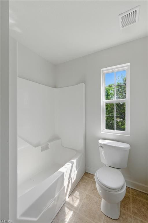 bathroom featuring baseboards, visible vents, toilet, and a bathing tub