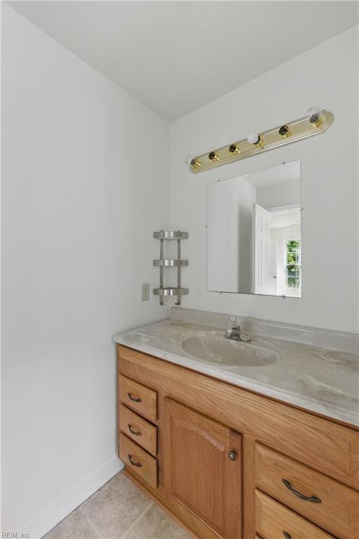 bathroom featuring tile patterned flooring, vanity, and baseboards