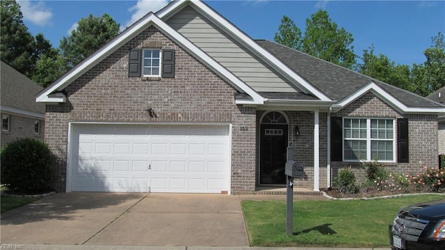 view of front of house featuring driveway, a front yard, and brick siding