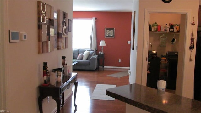 corridor with wood finished floors and baseboards